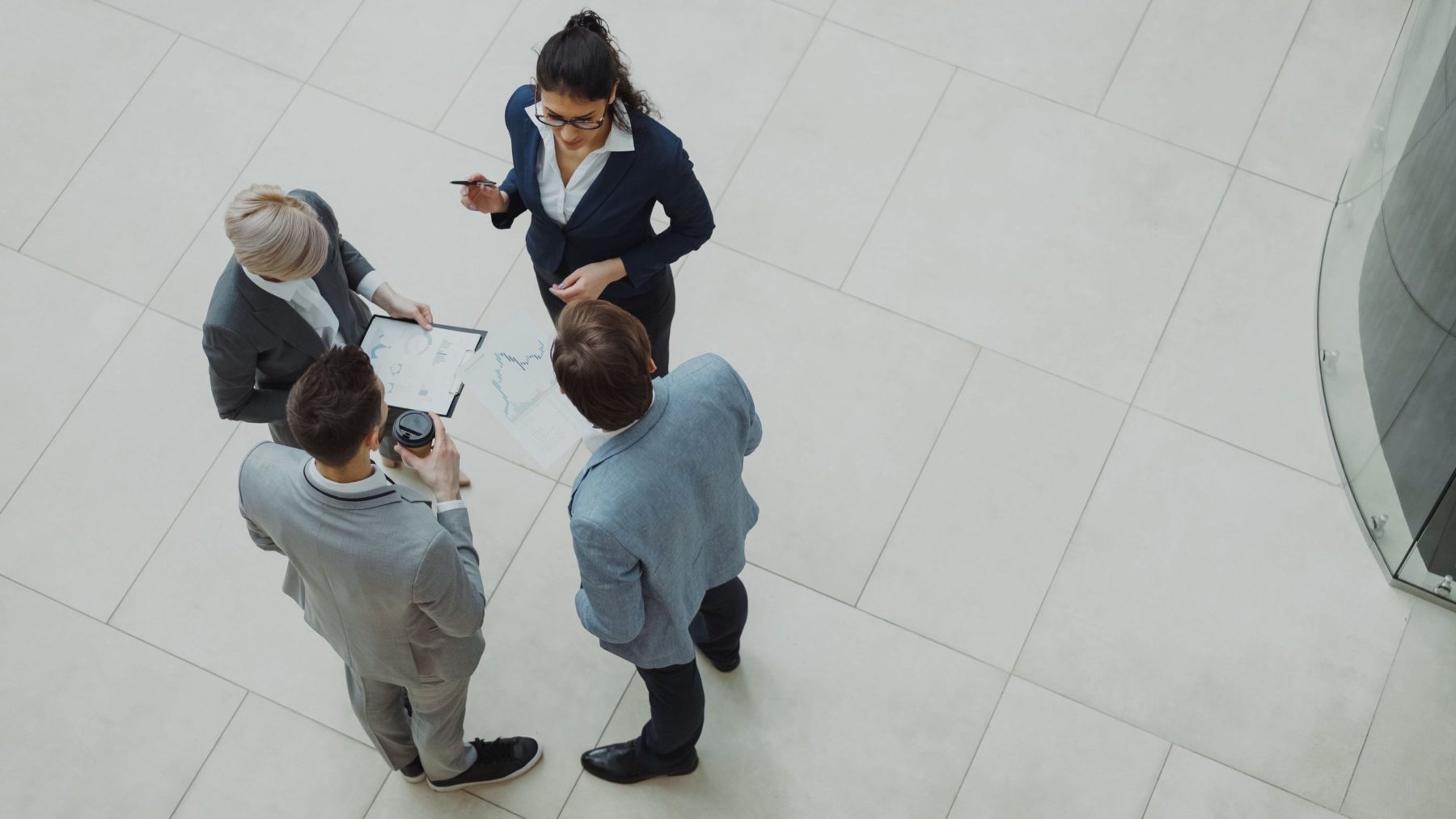 Four colleagues talking with paperwork, seen from above