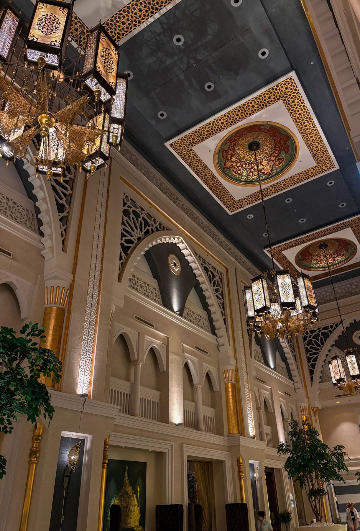 The inside of the shop seen through the front window, with warm lamps and a decorated ceiling