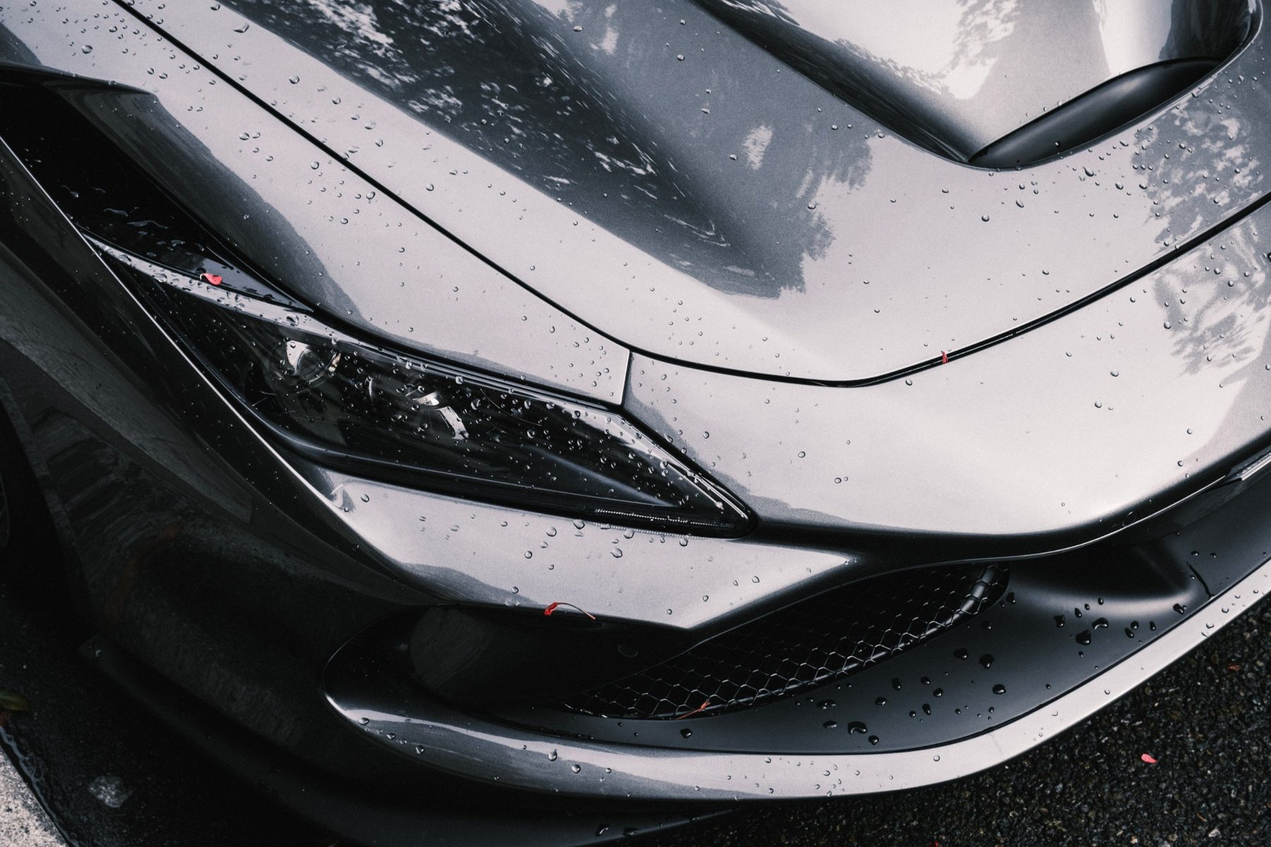 Close-up of the headlight of a grey performance car
