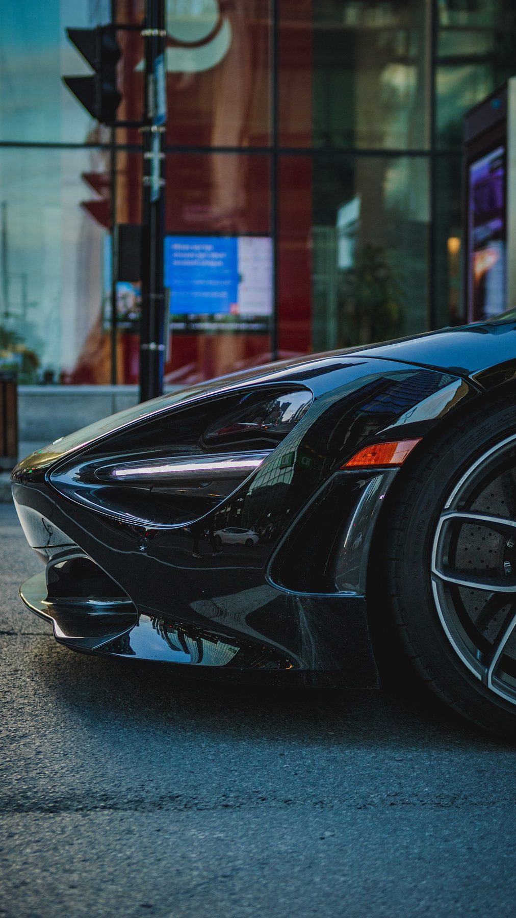 A dark performance car parked in the city
