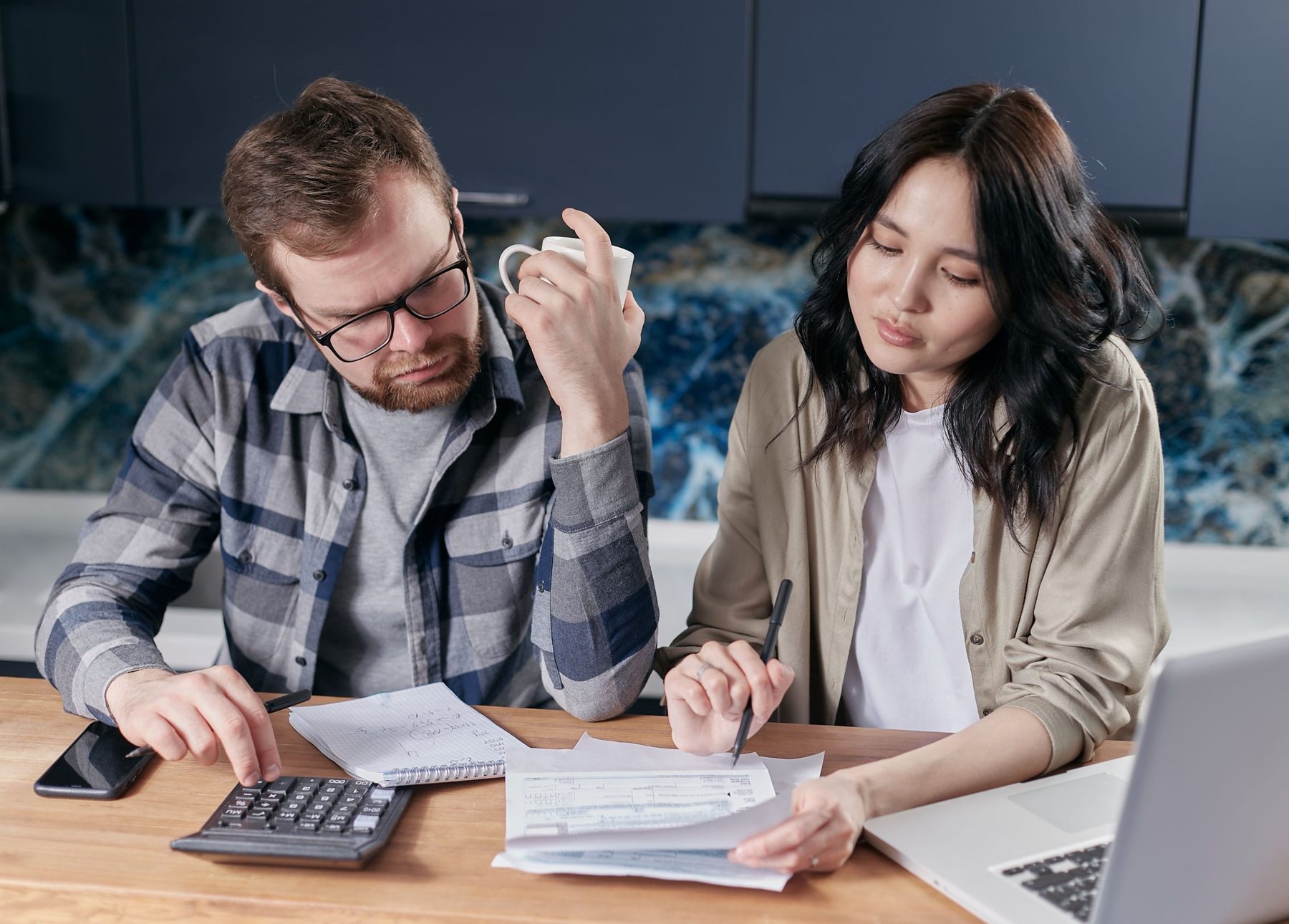 A couple sitting at a table going through paperwork together